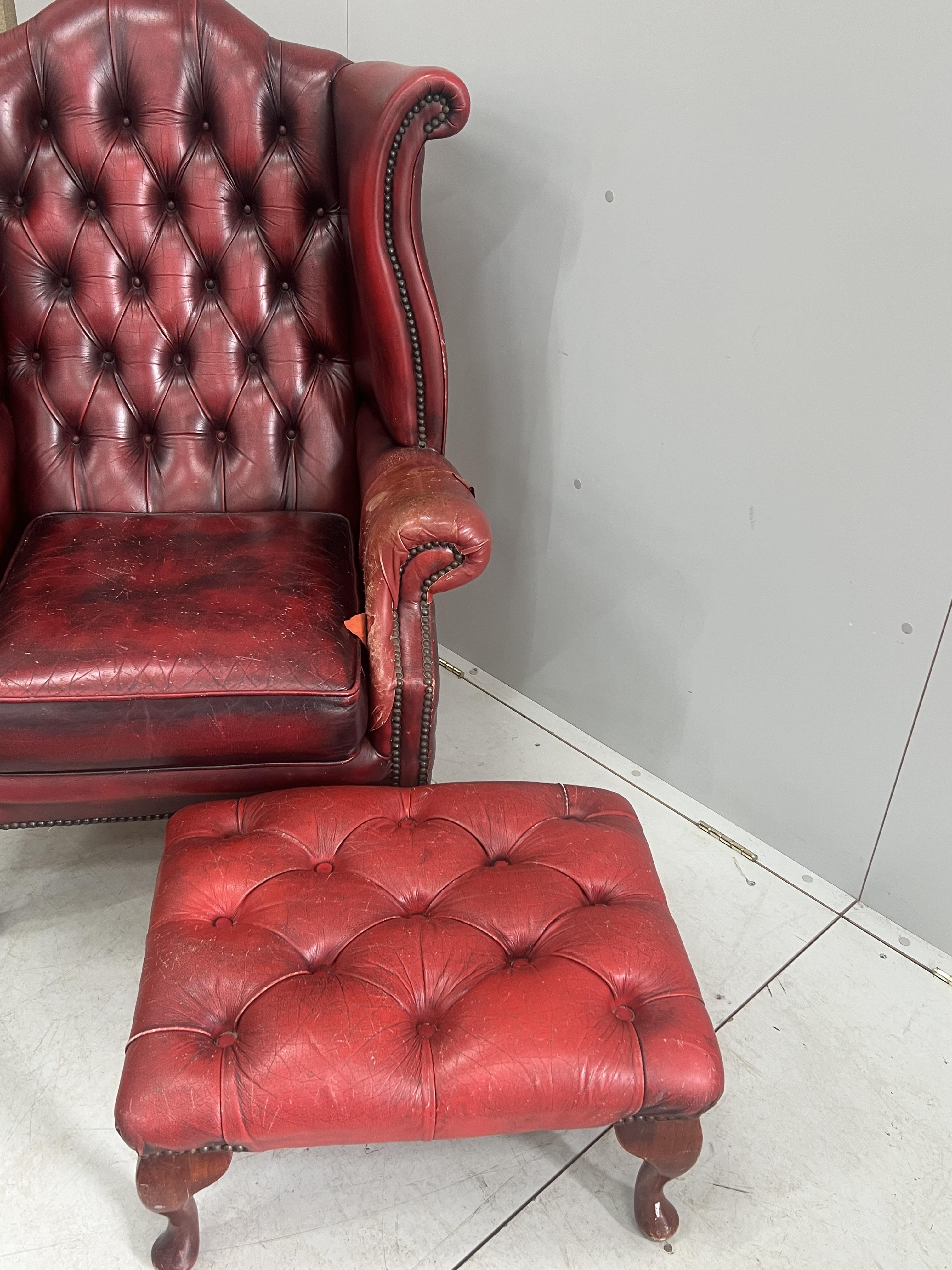 A Victorian style leather armchair, width 82cm, depth 80cm, height 110cm and footstool